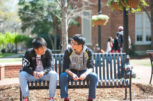 International students on bench outside of B.B. Comer
