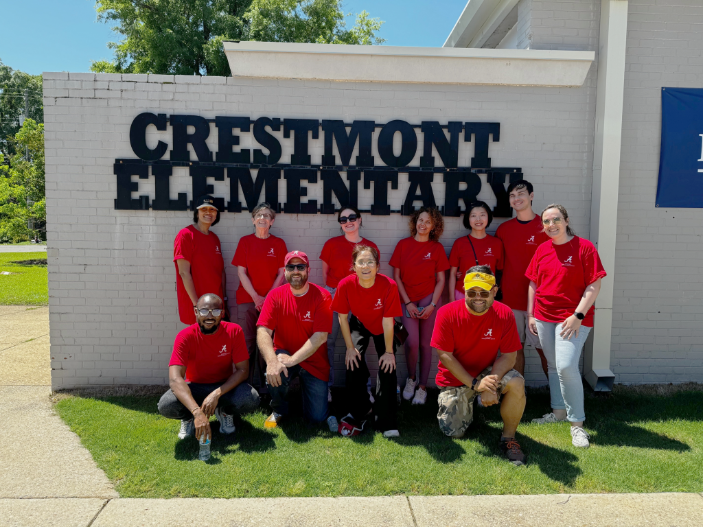 Group photo of CIC Day of Action volunteers standing in front of the Crestmont Elementary School sign.